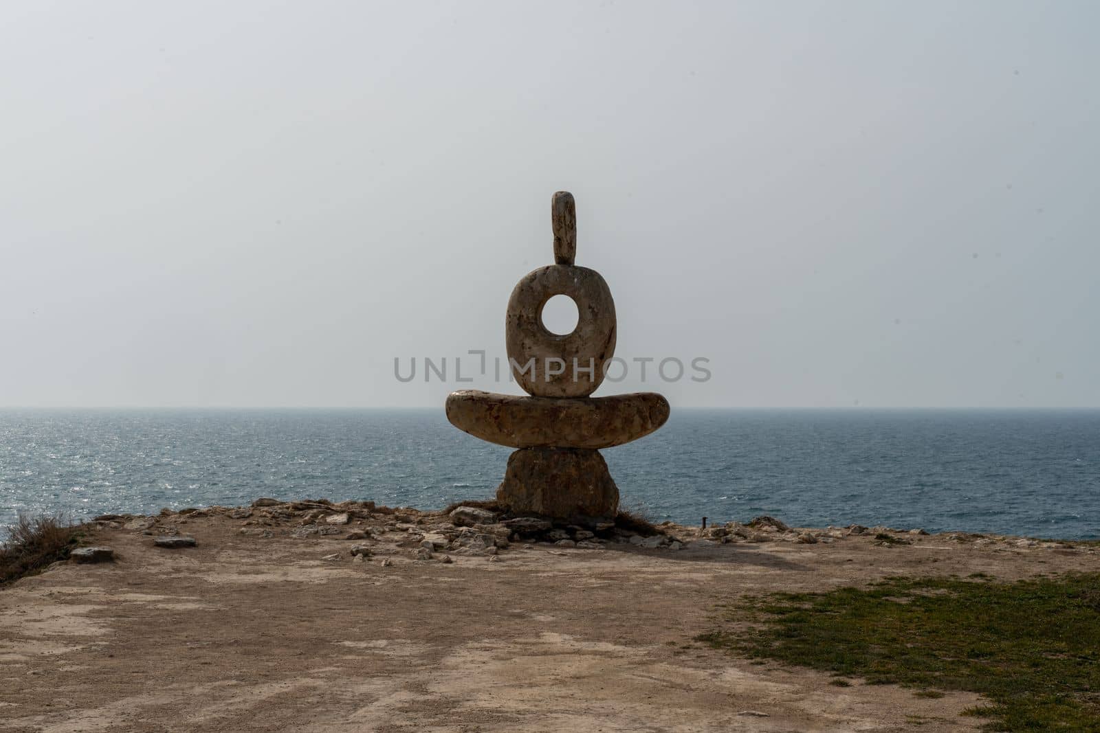 Sculpture symbol made of large pebbles against the blue sky.