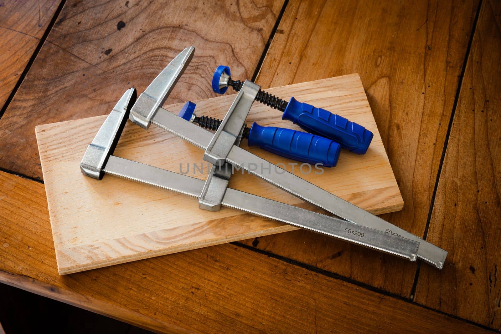 Restoration of an antique French wooden furniture using wood clamps to attach different parts of it