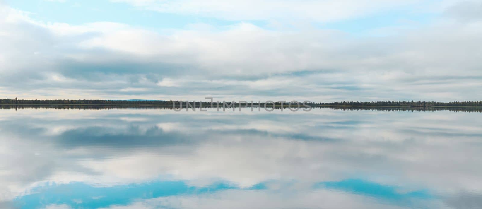 calm on a large lake, reflection of the sky in the water , summer evening