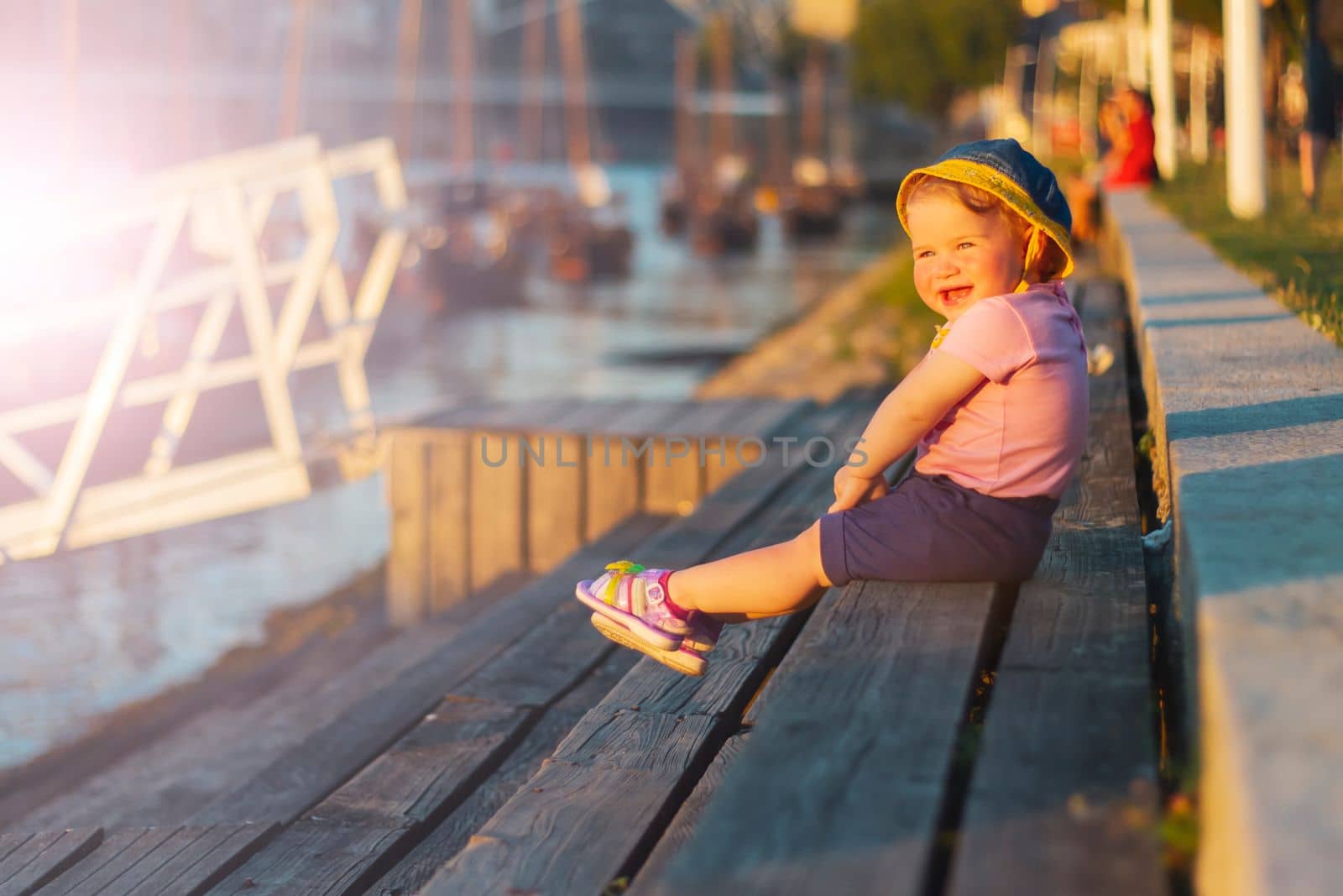 happy child near the river at sunset , summer evening