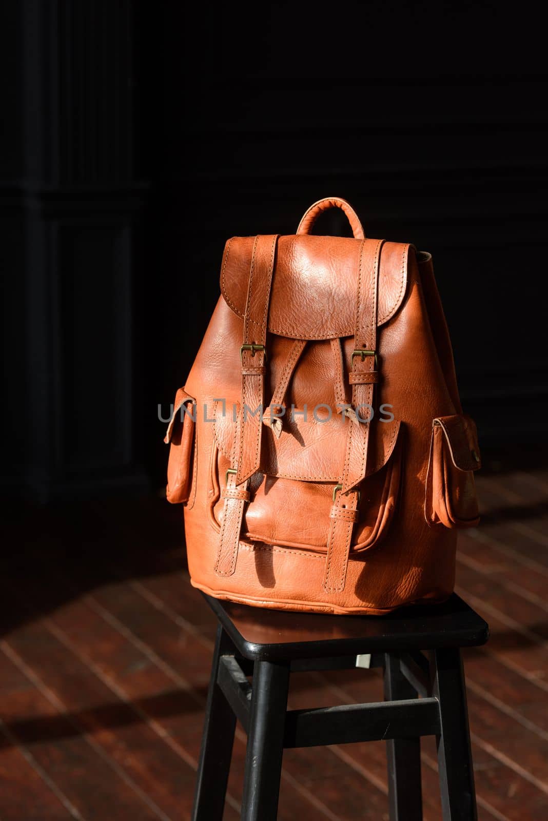 photo of a orange leather backpack with antique and retro look. indoors photo by Ashtray25