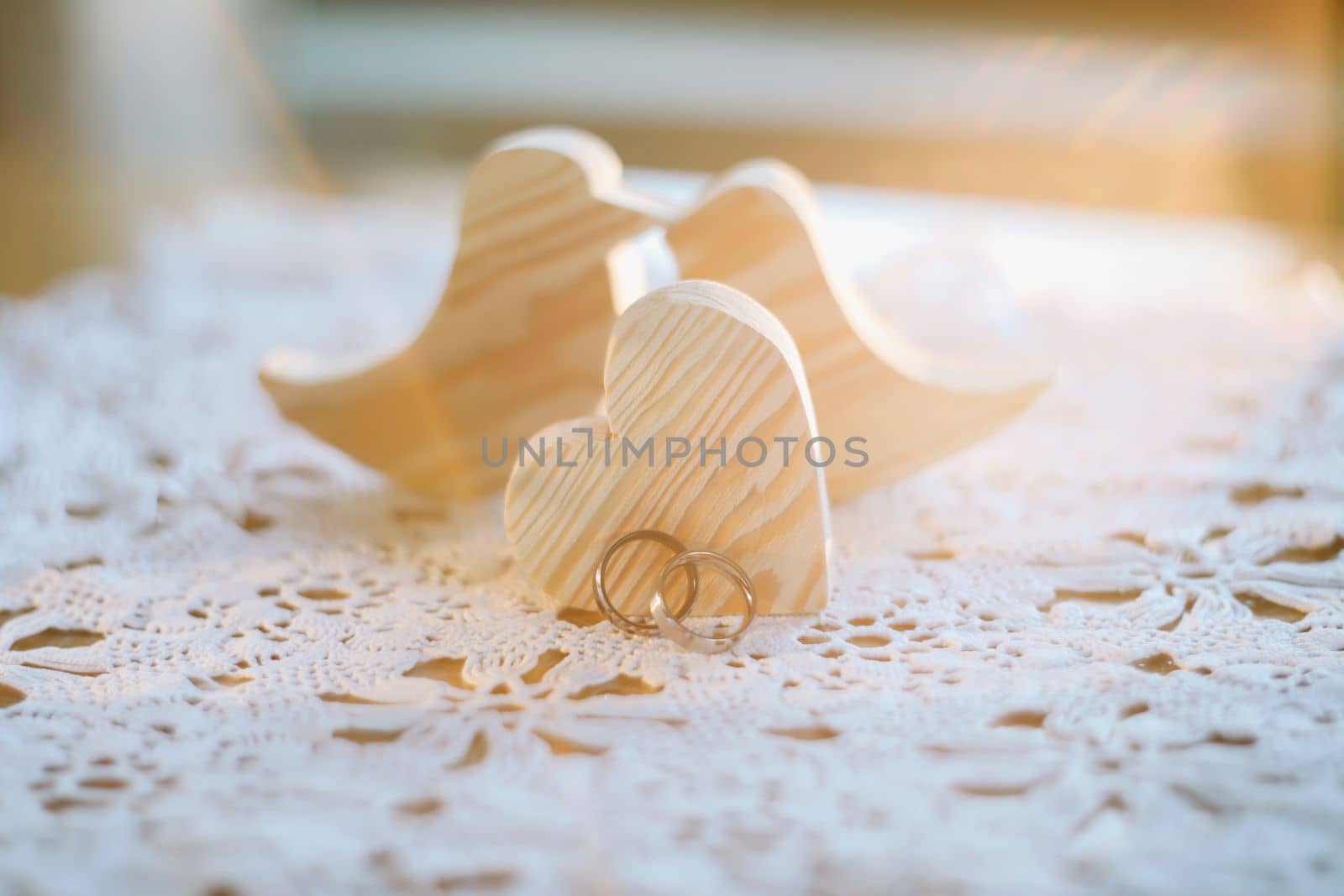 Two wooden handmade toy birds with two gold wedding rings and heart. Wedding, love, proposal, marriage, family concept.