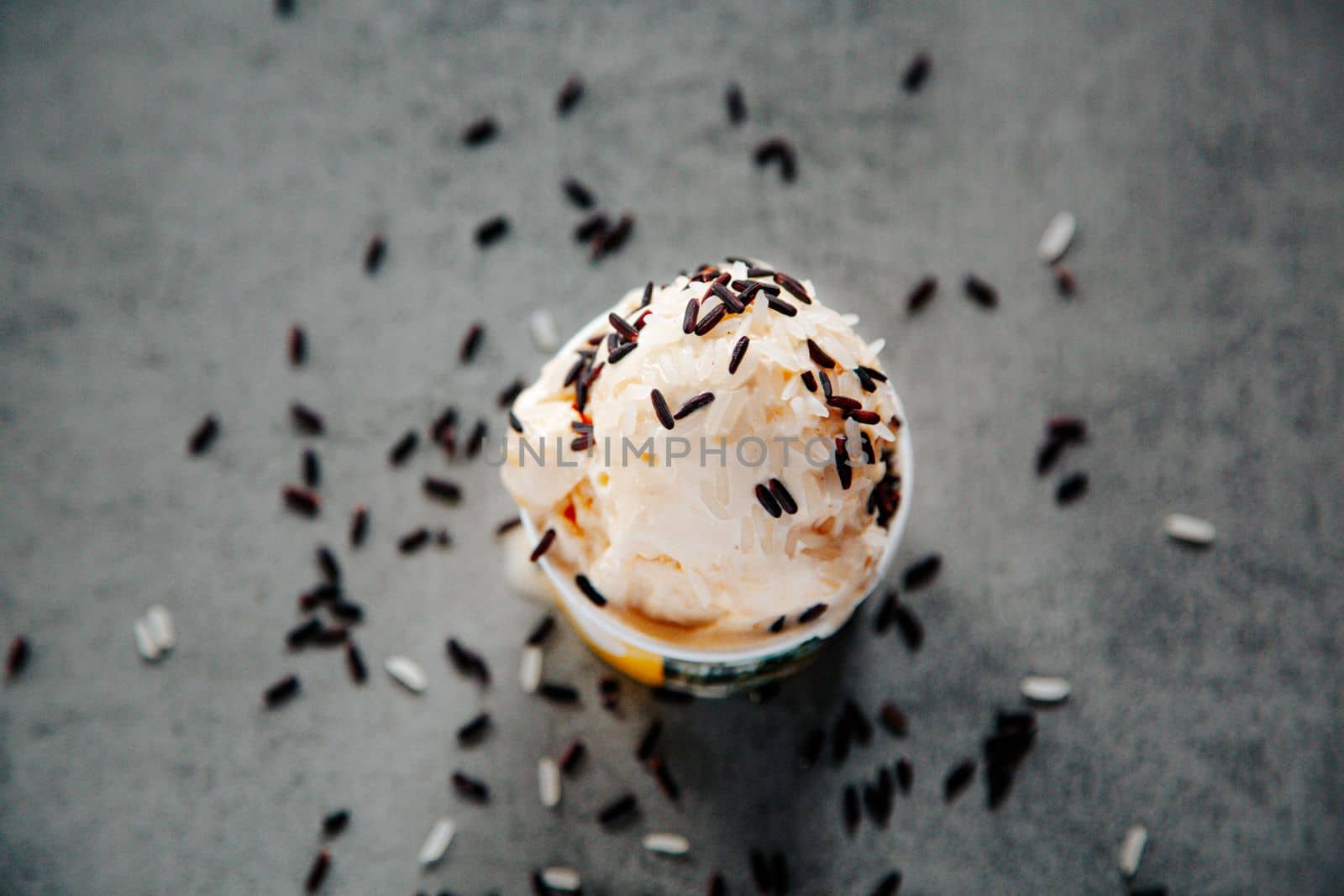 Rice Ice Cream on top of sweet sticky rice in the coconut shell on gray