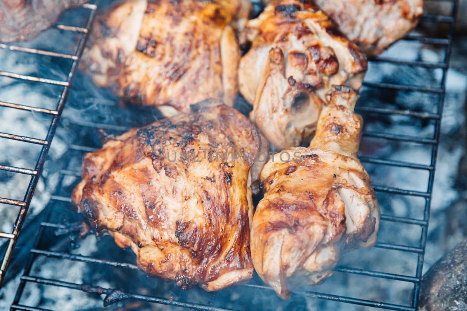 Chicken thighs Barbecue on The Hot Grill Close-up. Fire flames in the background