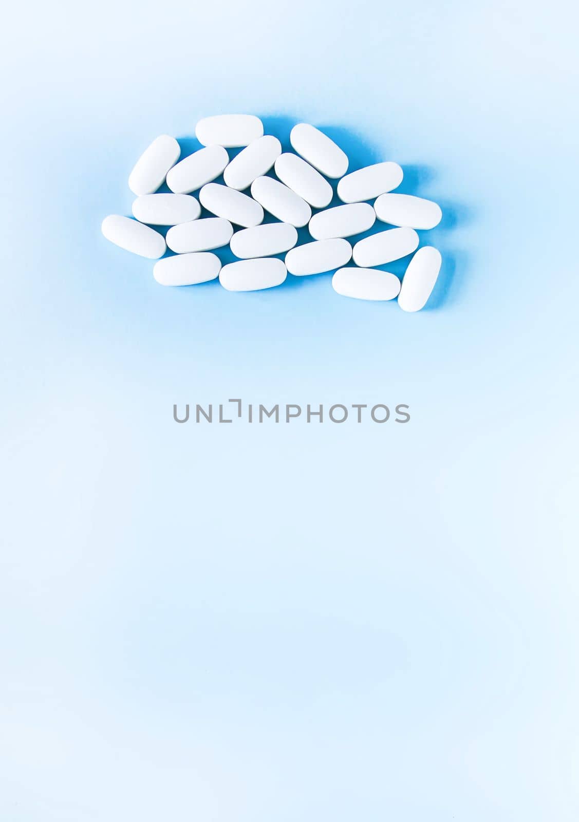 Pills of vitamin on soft blue background.