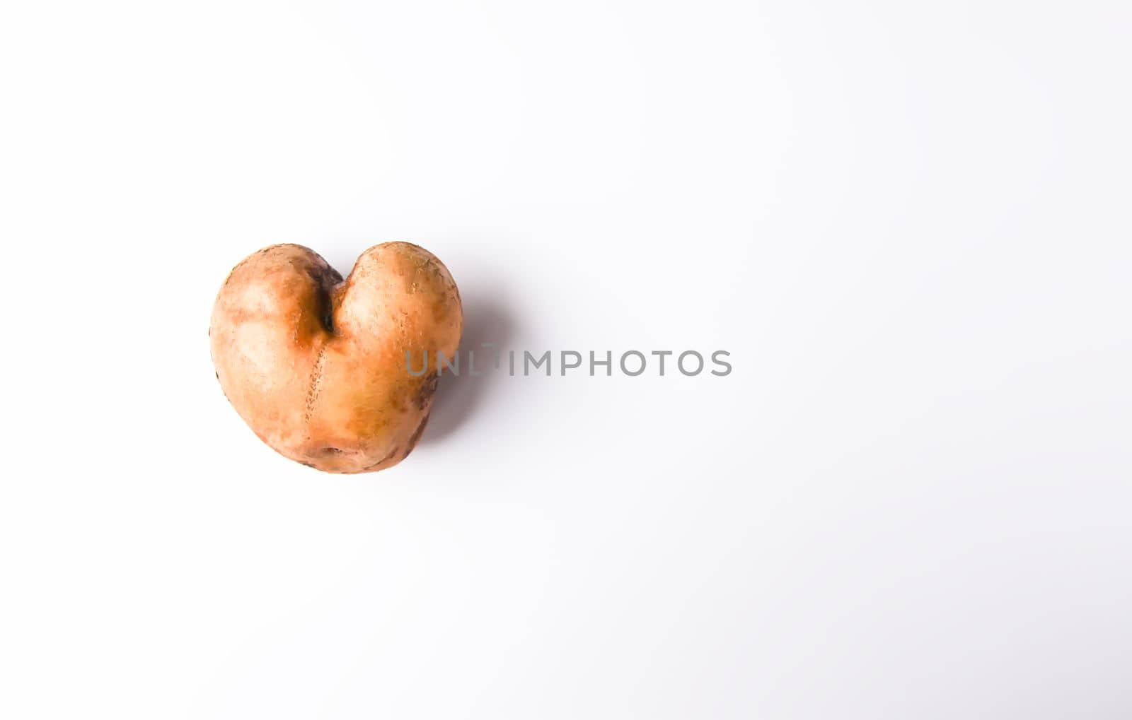 Heart shaped raw potato vegetable.Top view, copy space.