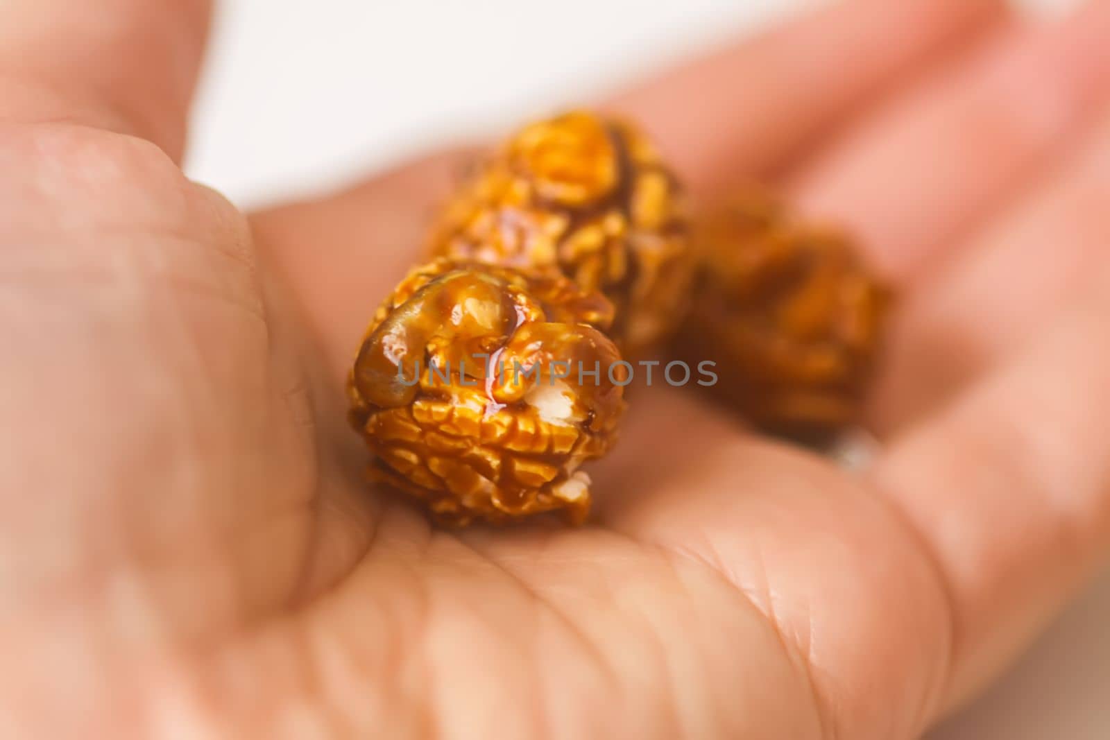 Sweet ready-to-eat popcorn in a hand close up.