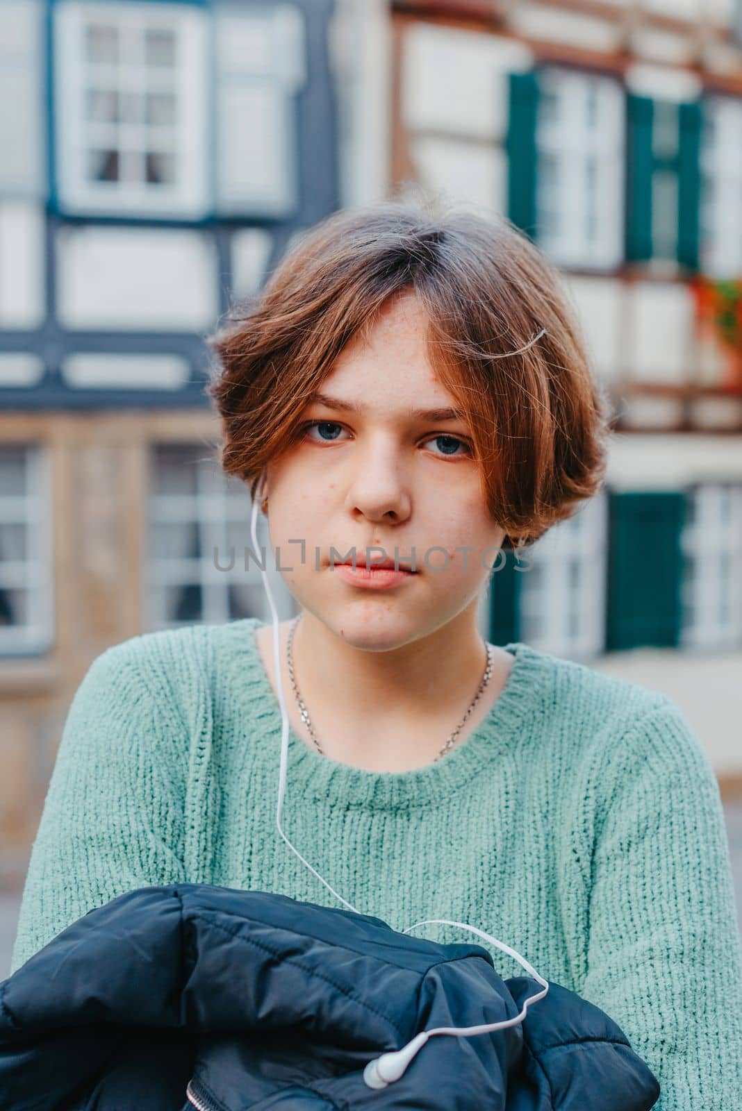 A Beautiful Girl Stands Against The Background Of The Window Of An Old European House. Tourism & Travel Concept. Nice Portrait Of A Young Woman, In Boho Style Outdoors In Fall Autumn Day. Caucasian Female Girl 12 Years Old.