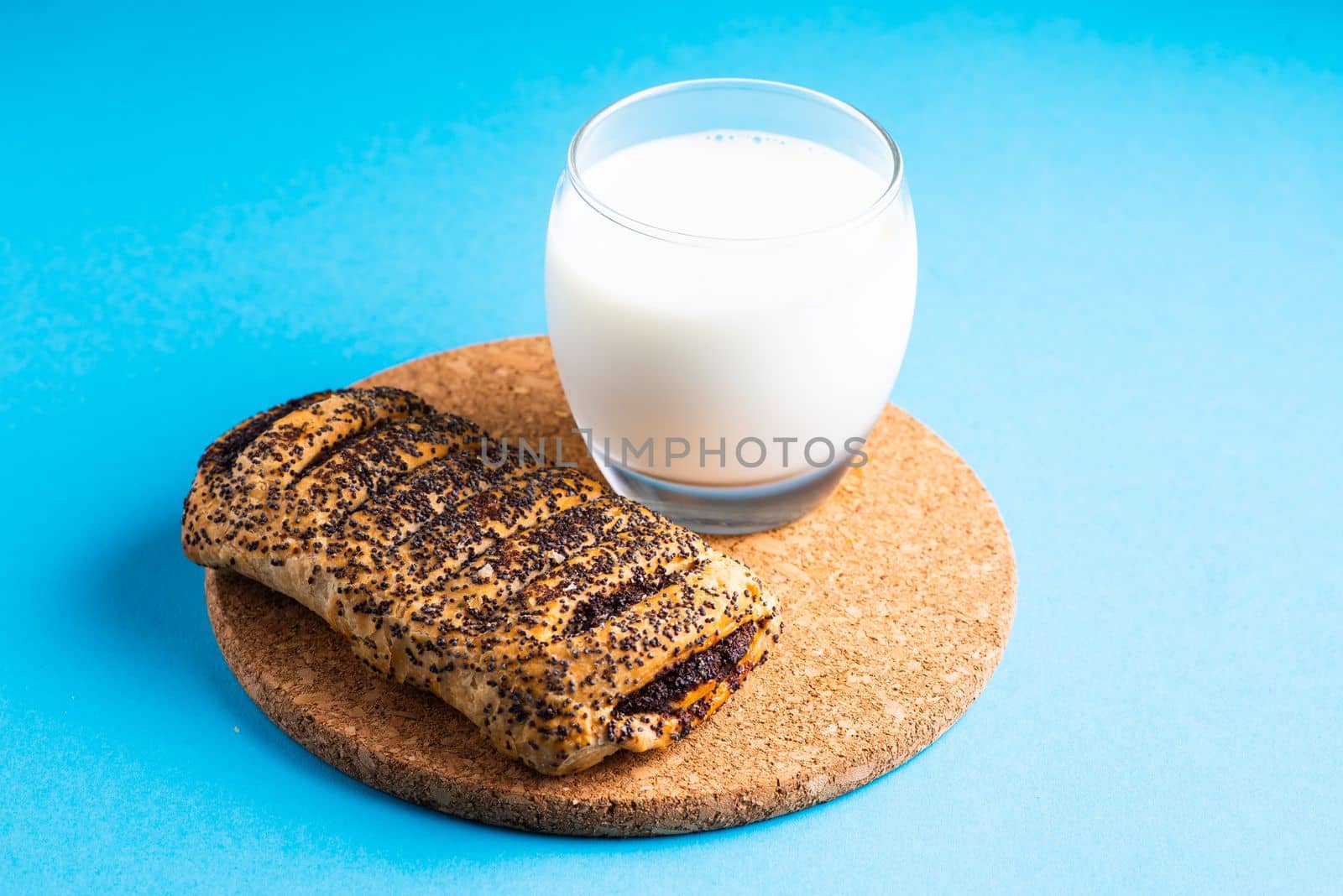 Breakfast bread and a cup of milk on yellow and blue background by Zelenin