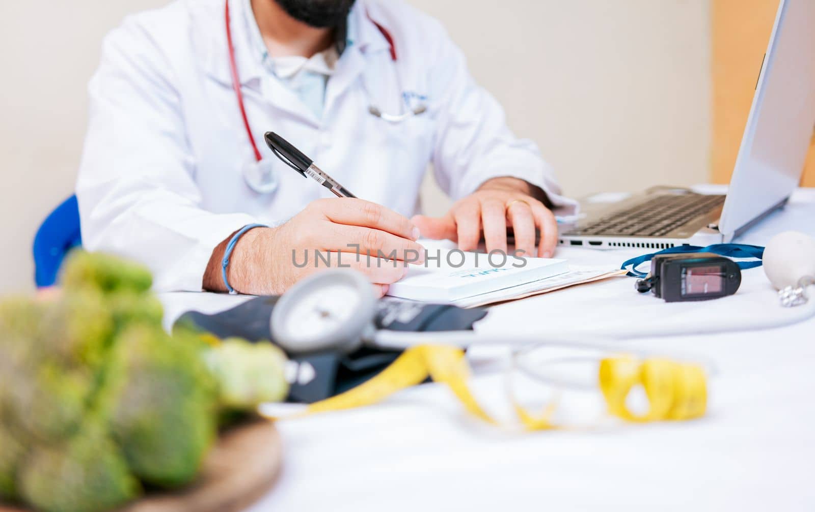 Close-up of nutritionist writing on notepad. Hands of male nutritionist taking notes at his desk, Nutritionist hands taking medical records in the office