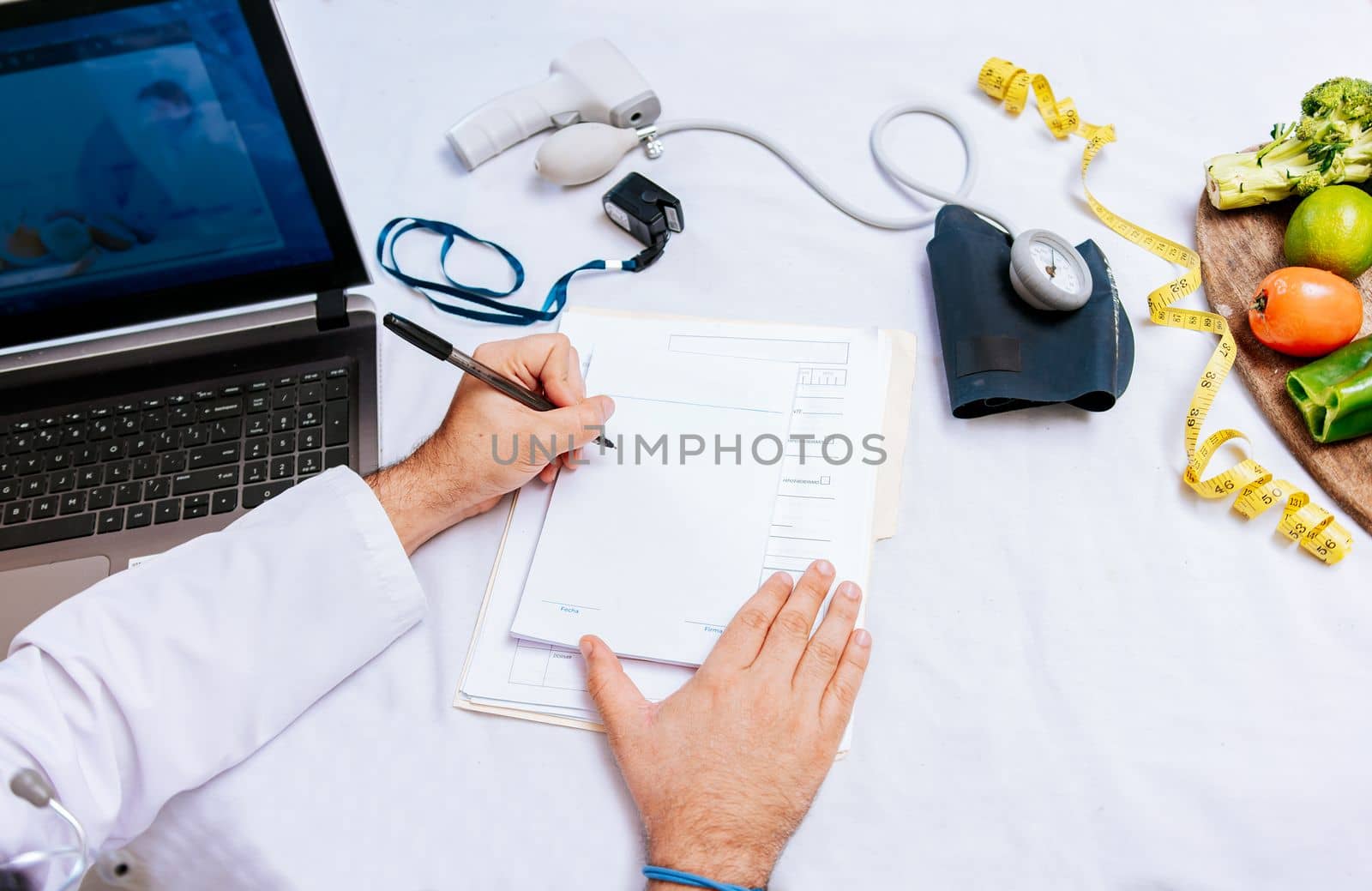 Top view of nutritionist writing on notepad. Concept of nutritionist taking notes on prescription, View of nutritionist taking medical records in the office by isaiphoto