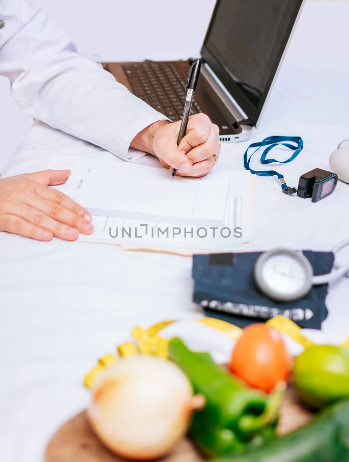 Hands of male nutritionist taking notes at his desk, Nutritionist hands taking medical records in the office. Close-up of nutritionist writing on notepad