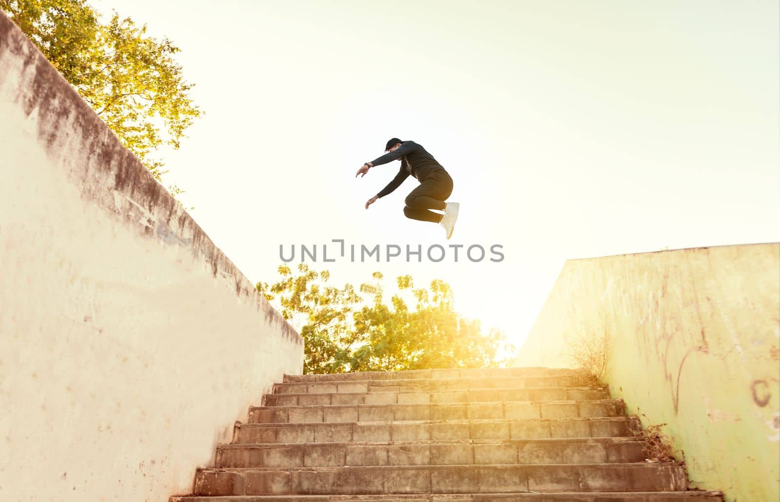 Man doing parkour jumping walls. Latin man doing parkour jumping walls, Low angle of man doing parkour at sunset