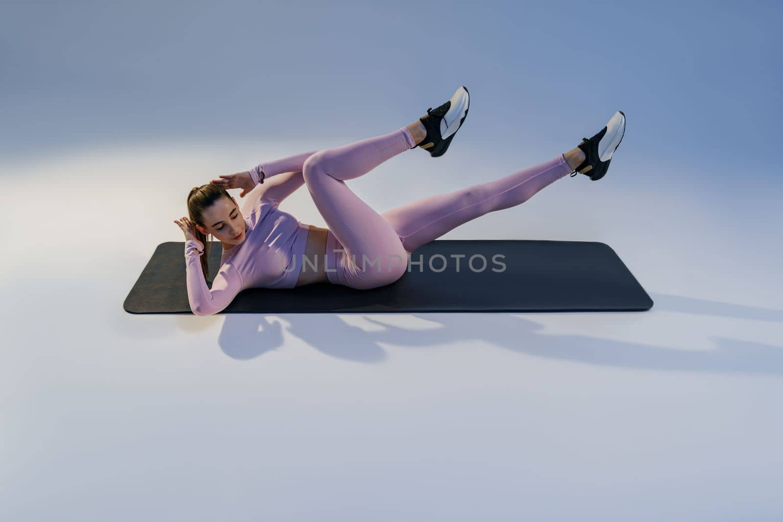 Athletic woman shaking press on studio background. Fitness, healthy lifestyle and sport concept by Yaroslav_astakhov