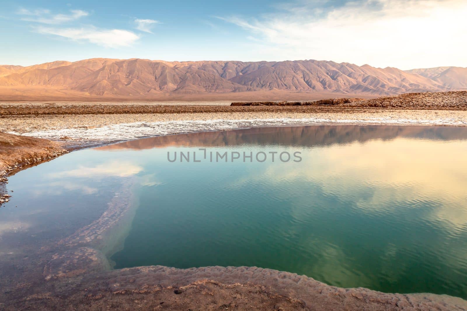 Salt lake reflection and idyllic volcanic landscape at sunrise, Atacama desert, Chile border with Bolivia