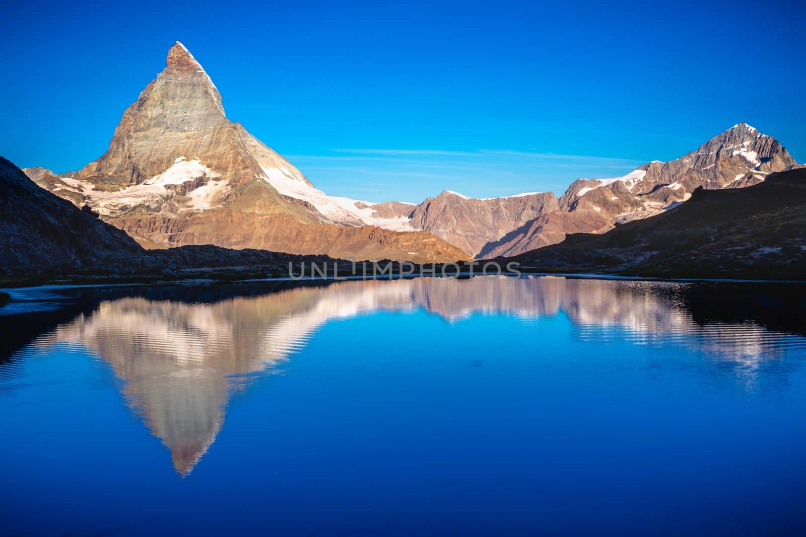 Reflection of the Matterhorn on blue lake at sunrise, Swiss Alps, Zermatt by positivetravelart