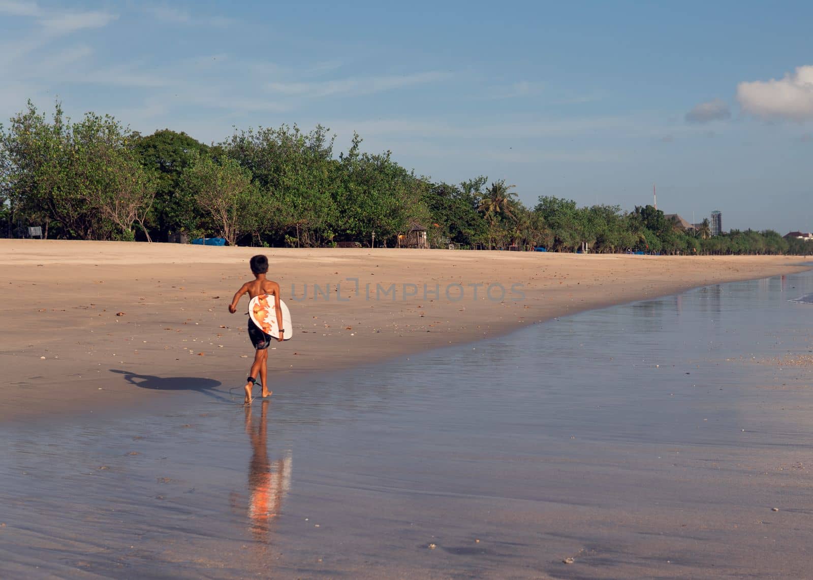 surfer walking along the beach by Alexzhilkin