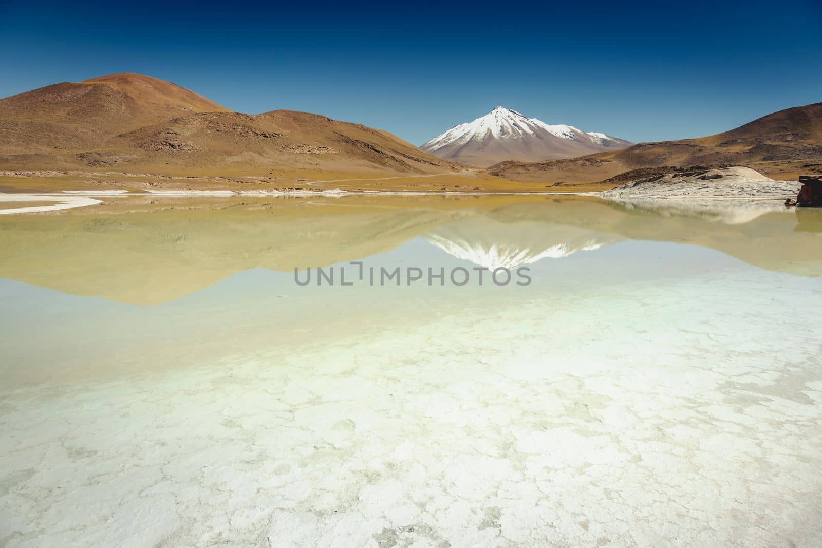 Salt lake reflection and idyllic volcanic landscape at sunrise, Atacama desert, Chile border with Bolivia