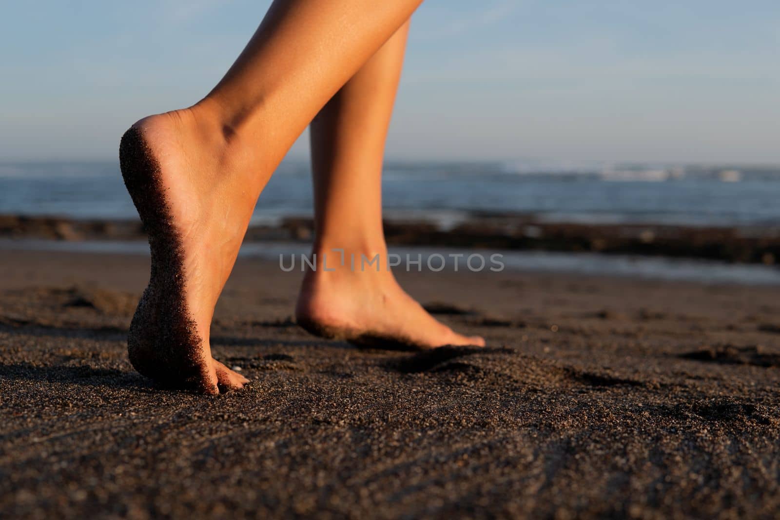 close-up. feet on black sand by Alexzhilkin