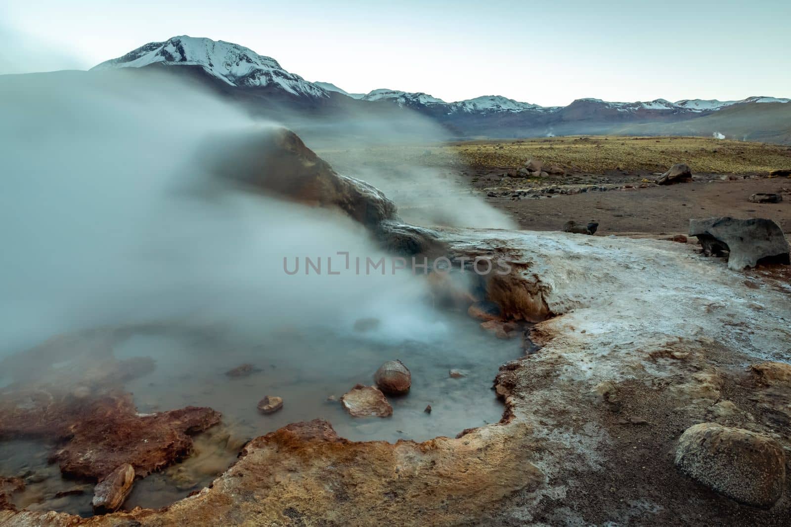 Geysers El Tatio with river and Peaceful dramatic volcanic landscape at sunrise, Atacama Desert, Chile