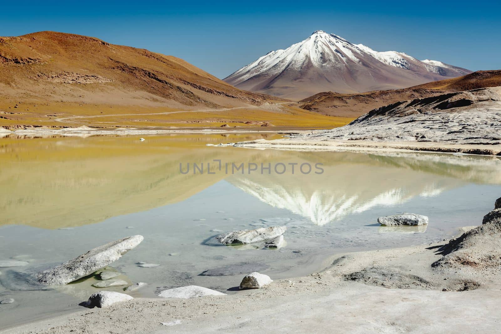 Salt lake reflection and idyllic volcanic landscape at sunrise, Atacama desert, Chile border with Bolivia