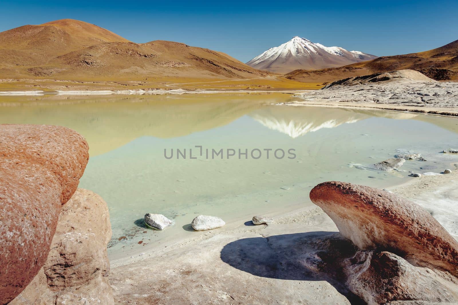 Salt lake reflection and idyllic volcanic landscape at sunrise, Atacama desert, Chile border with Bolivia