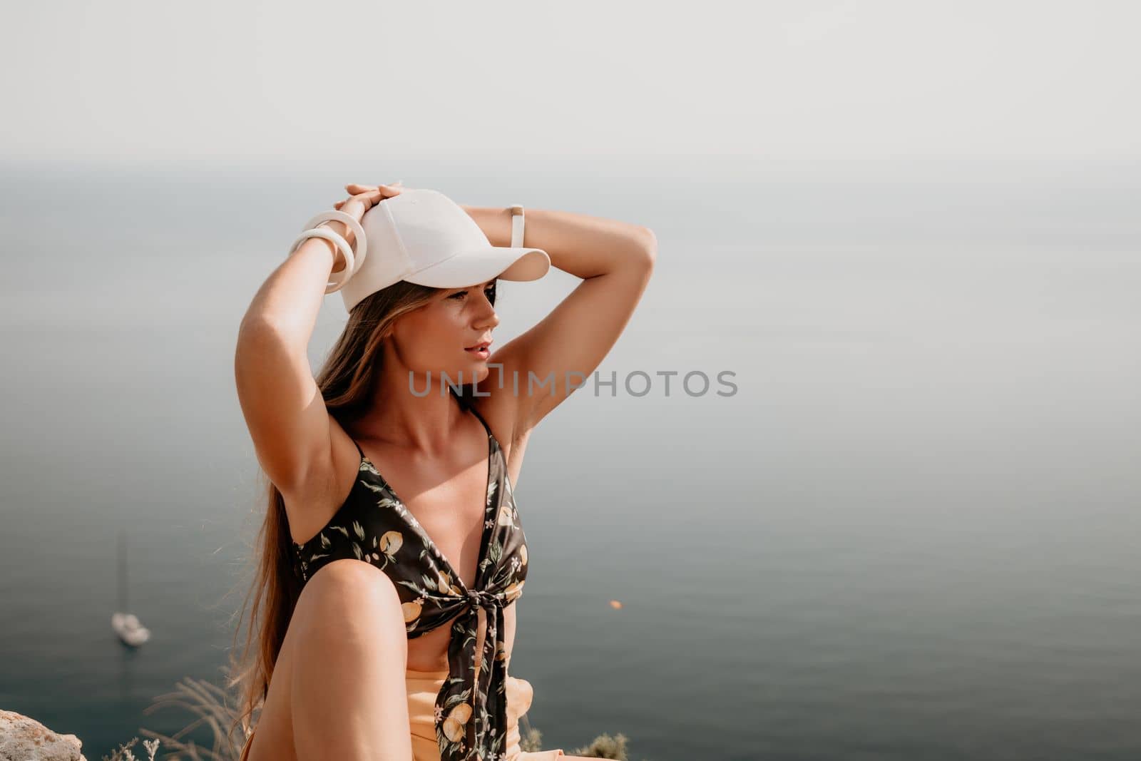 Woman travel sea. Happy tourist taking picture outdoors for memories. Woman traveler looks at the edge of the cliff on the sea bay of mountains, sharing travel adventure journey.