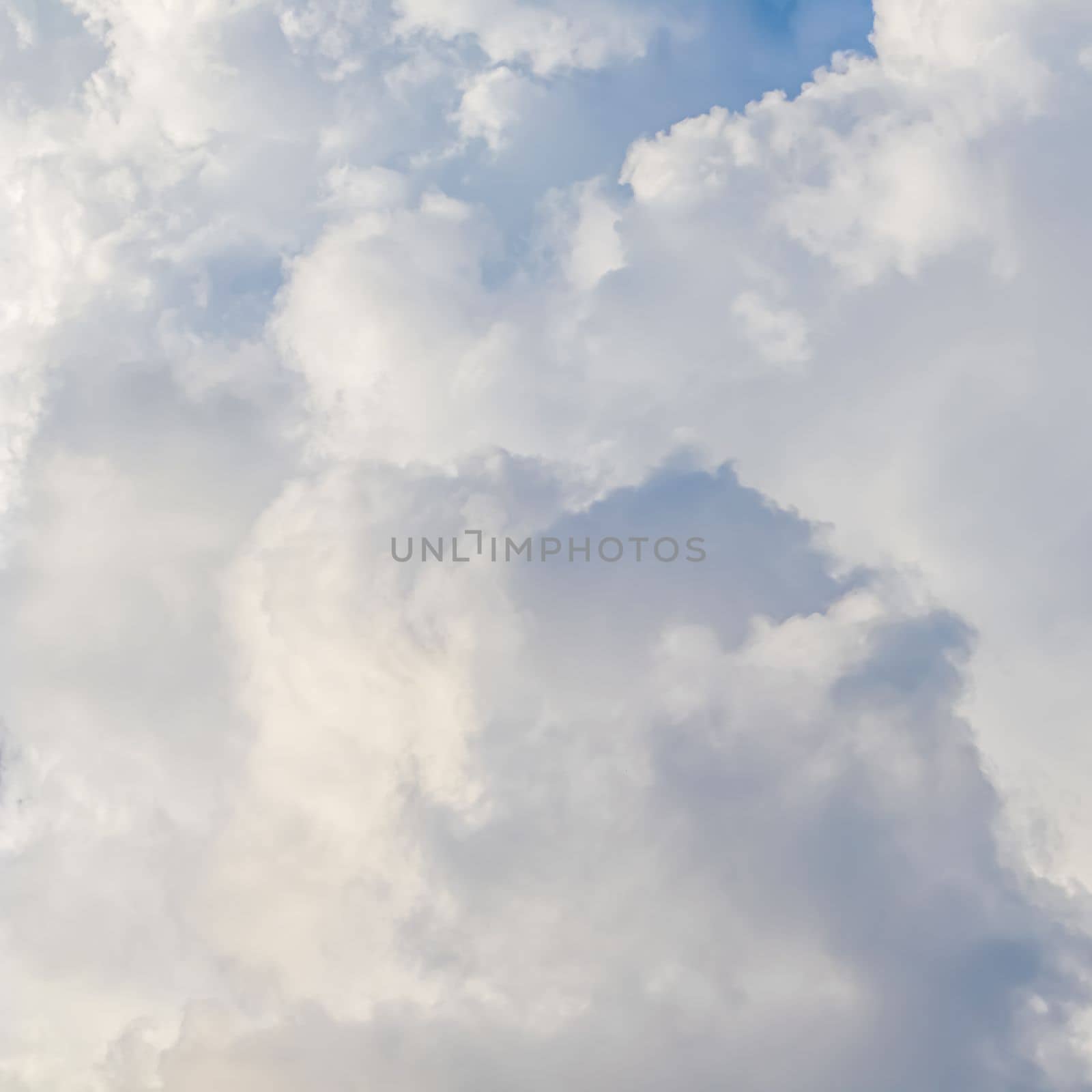 Cloudy sky background with sunlight shining through white clouds. Natural backdrop