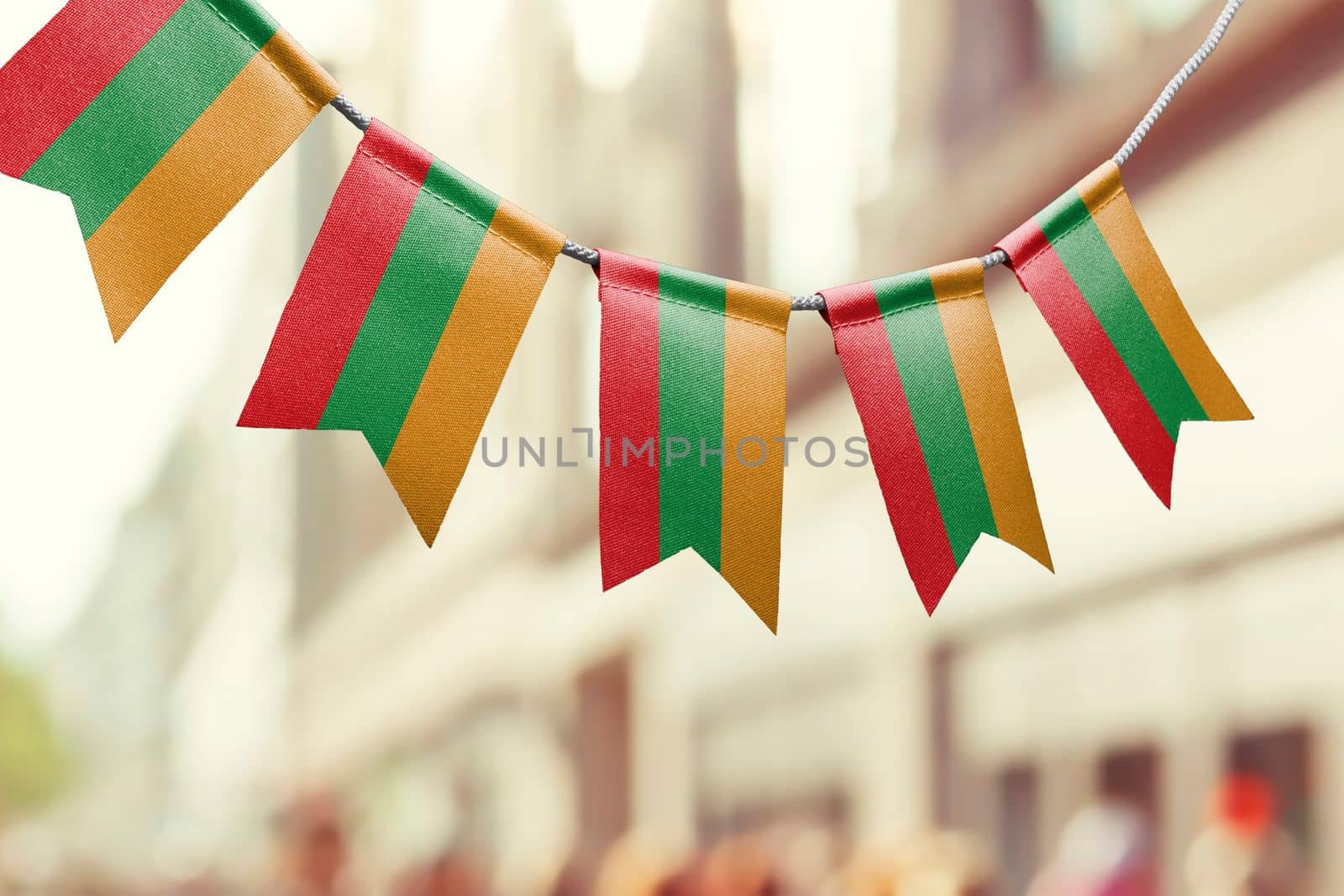 A garland of Lithuania national flags on an abstract blurred background by butenkow
