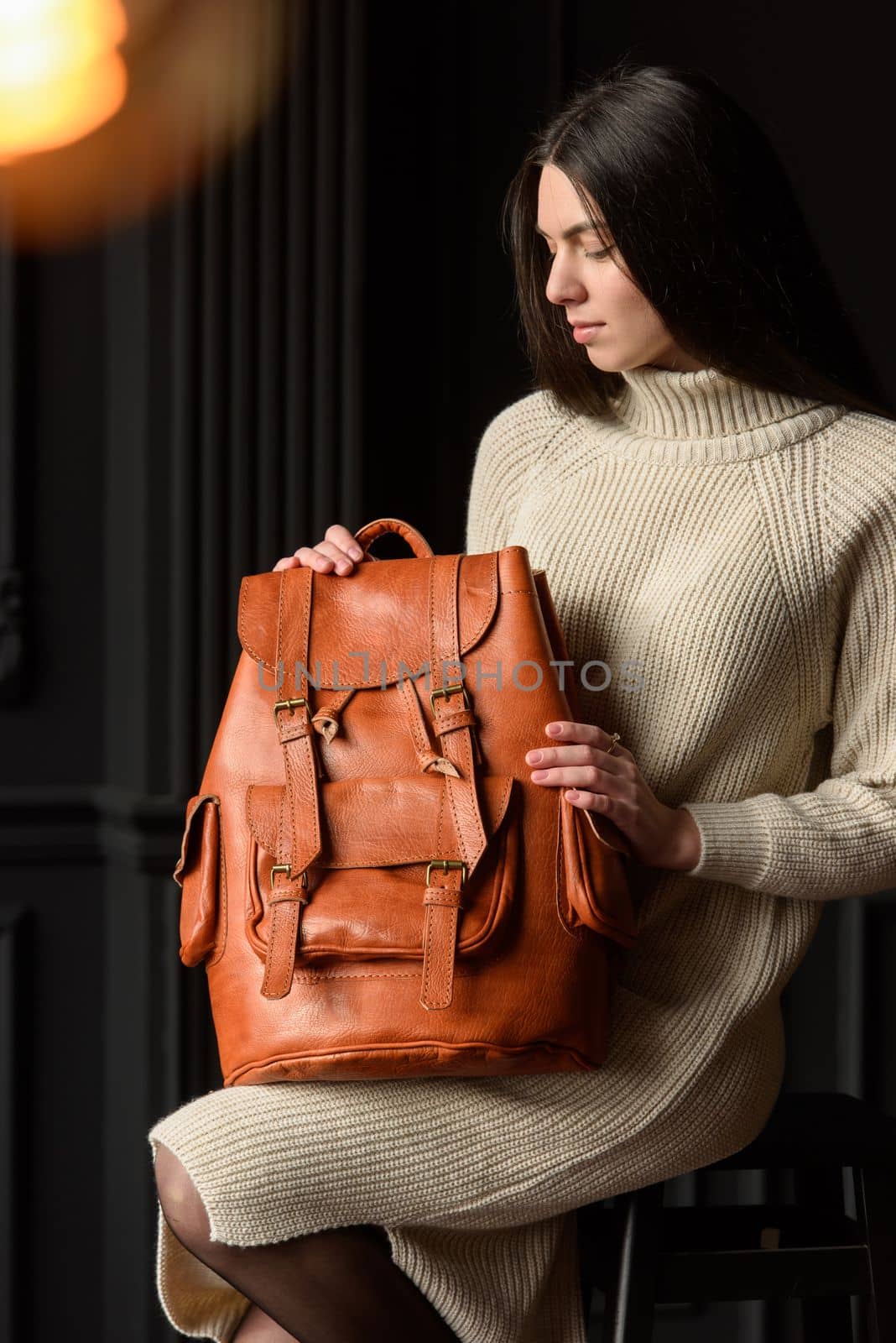 photo of a woman with a orange leather backpack with antique and retro look. indoors photo by Ashtray25