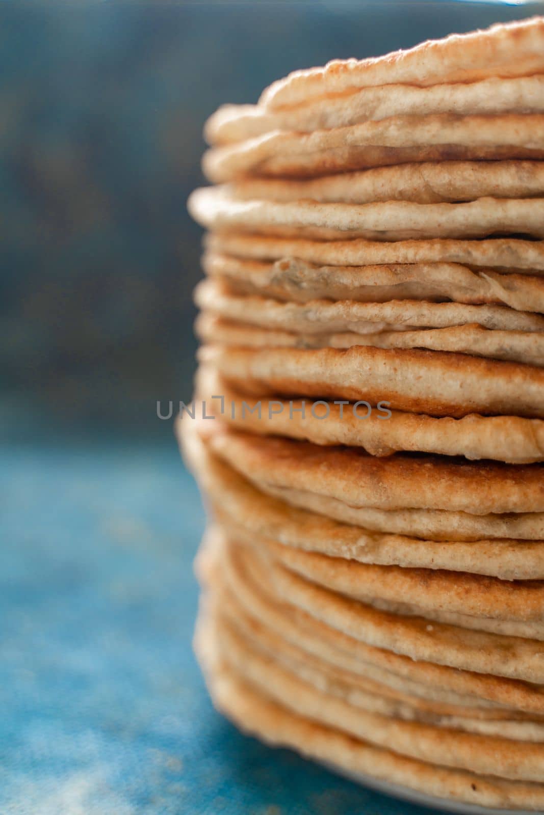 Flatbread lavash, chapati, naan, heap of tortilla on a blue background Homemade flatbread stacked