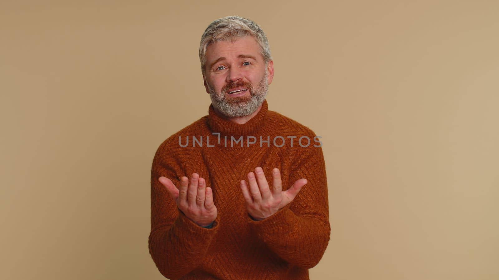 Senior middle-aged man feeling hopelessness loneliness, nervous breakdown, loses becoming surprised by lottery results, bad fortune, loss, unlucky news. Mature guy isolated on studio beige background