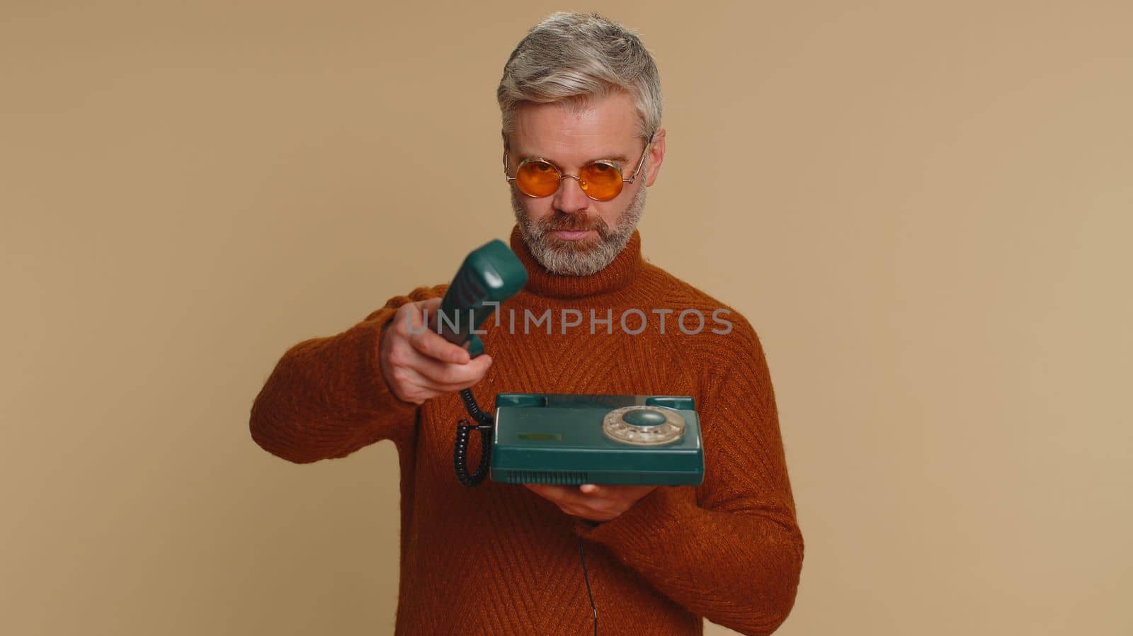 Middle-aged old man talking on wired vintage old-fashioned telephone of 80s advertising call me back by efuror