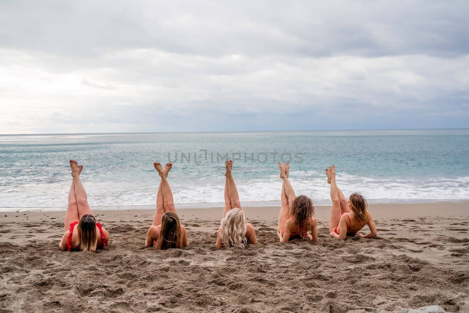 Big happy family or group of five friends is having fun against sunset beach. Beach holidays concept