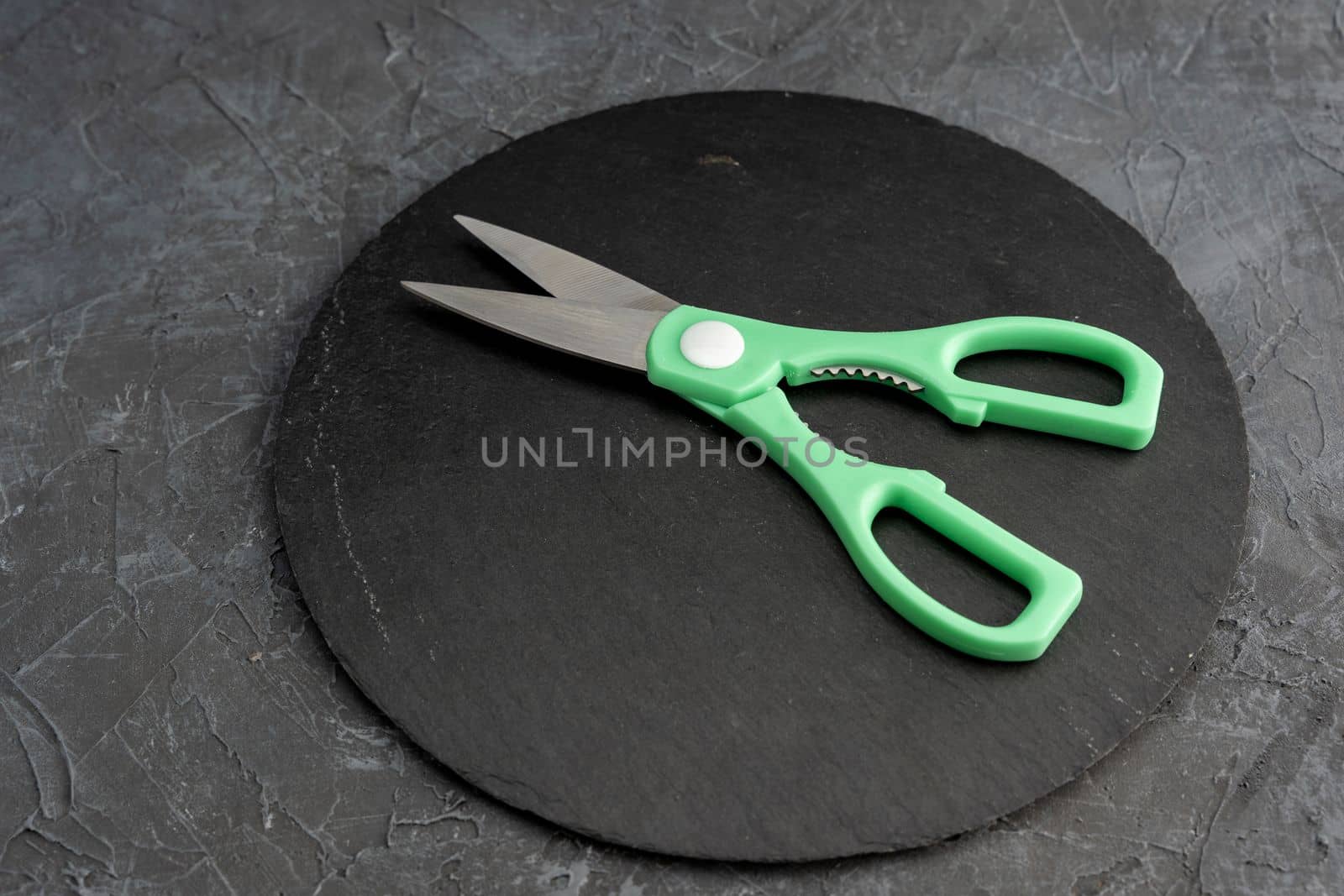 sharp kitchen scissors on a black slate cutting board in the kitchen. by audiznam2609