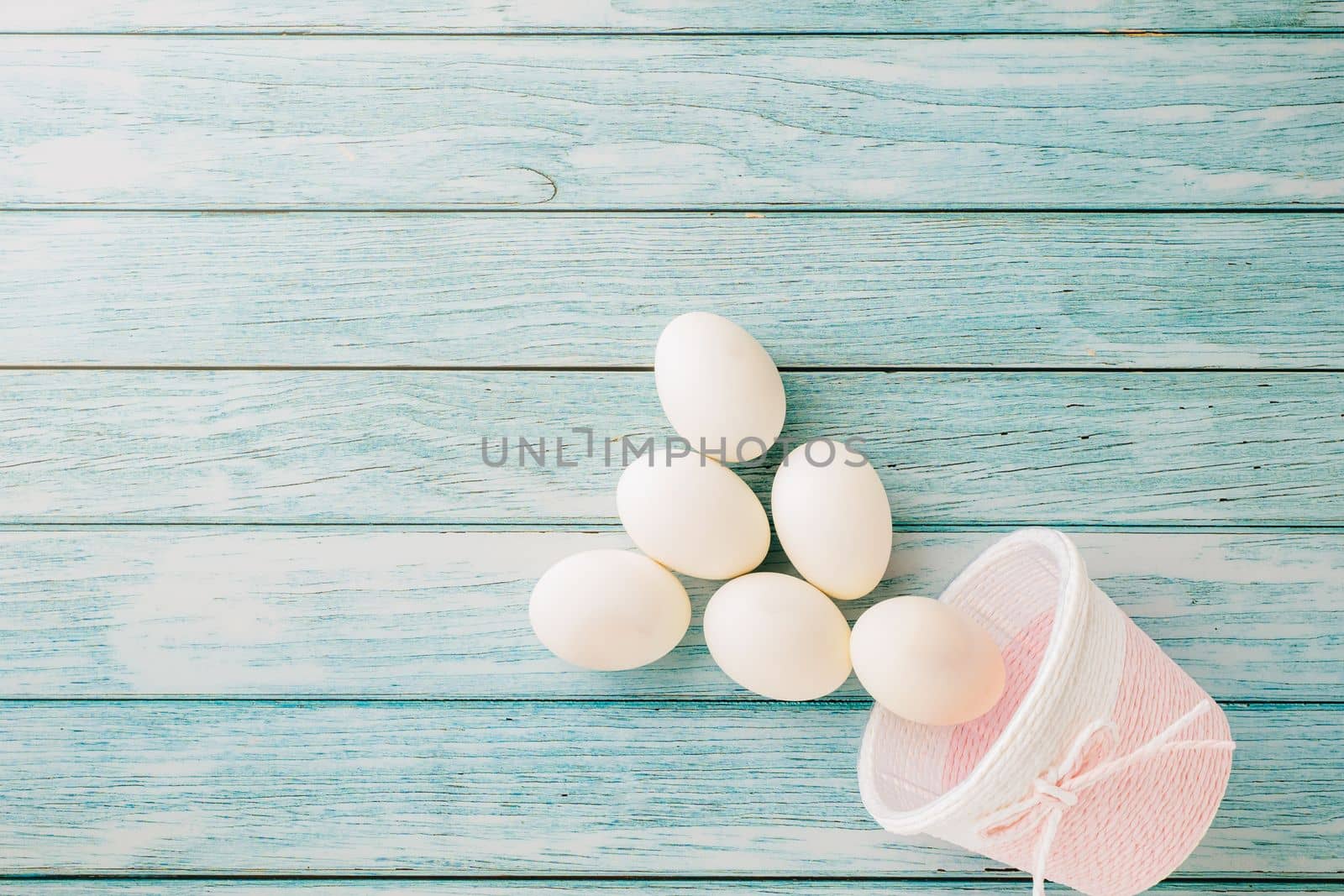 Happy Easter Day Concept. Top view of holiday banner background design white easter eggs and basket on blue wooden background with empty copy space, celebration greeting card