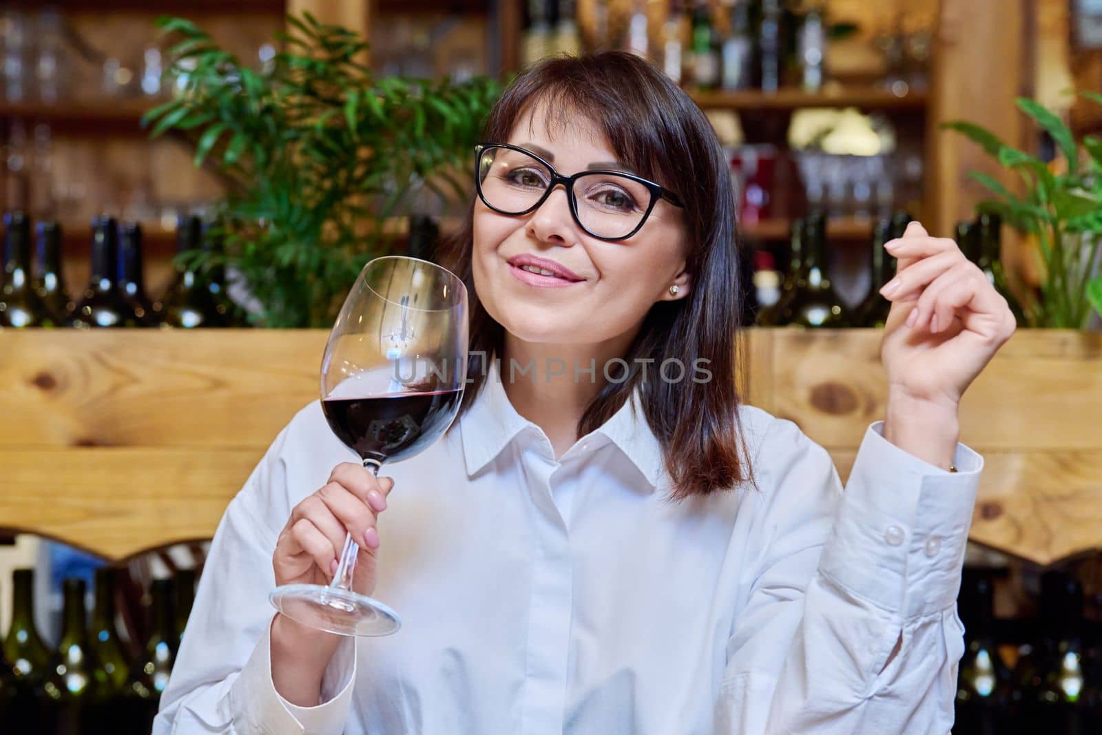 Middle aged happy woman drinking glass of red wine in restaurant. Relax, leisure, dinner, lifestyle, 40s people concept