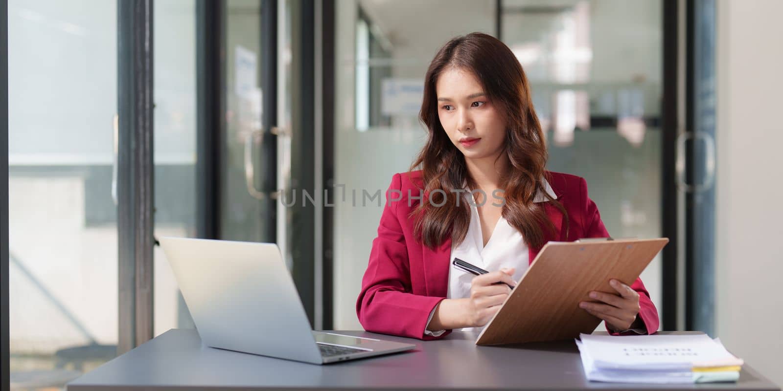 Stressed Business woman checking budget of company, taxes, bank account balance and calculating expenses at office.