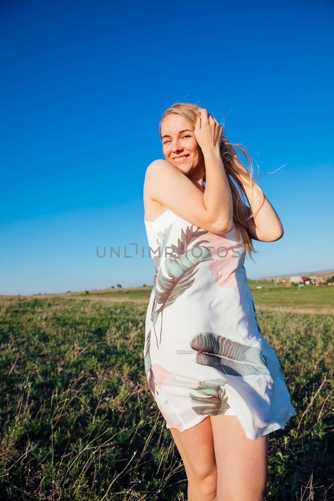a woman in a beautiful summer dress in nature in a clearing by Simakov