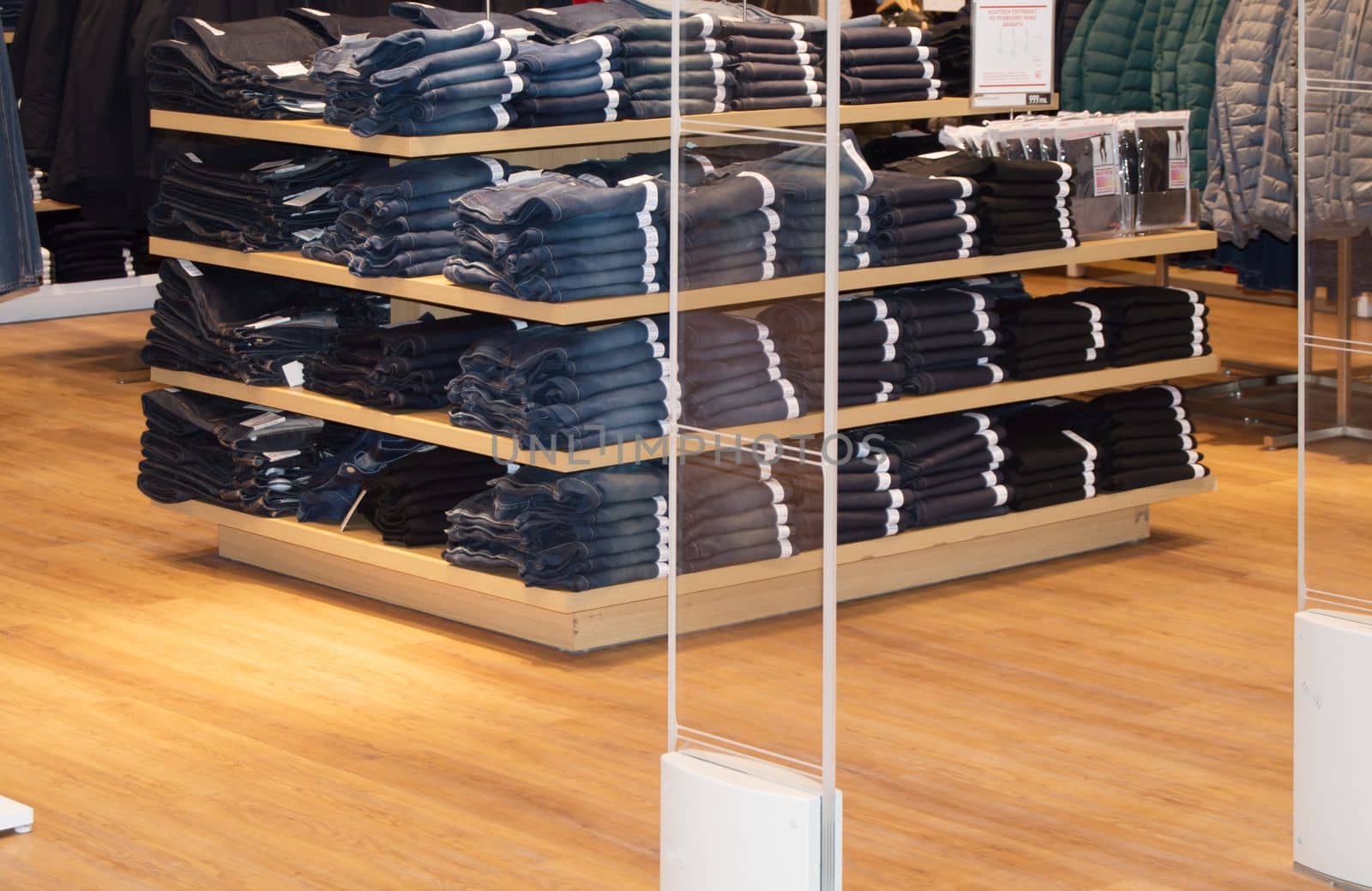 Jeans are stacked on the counter in a clothing store.