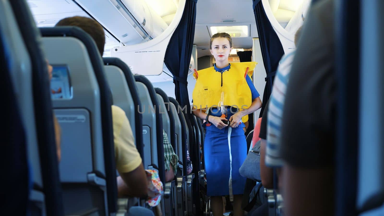 AIRPORT BORYSPIL, UKRAINE - OCTOBER 24, 2018: Ukraine International Airlines. Stewardess in cabin of passenger airplane instructs passengers on safety measures in event of an emergency. High quality photo