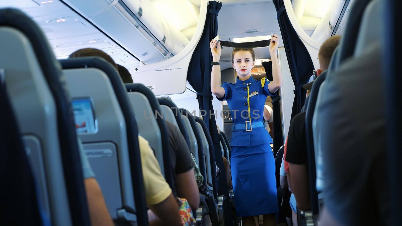 AIRPORT BORYSPIL, UKRAINE - OCTOBER 24, 2018: Ukraine International Airlines. Stewardess in cabin of passenger airplane instructs passengers on safety measures in event of an emergency by djtreneryay