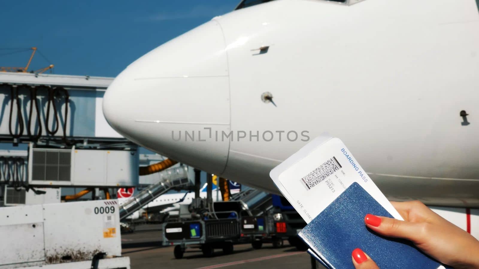 Close-up, female hands holding Airline boarding pass tickets, Boarding pass and passport at airport, on the background of the aircraft. High quality photo