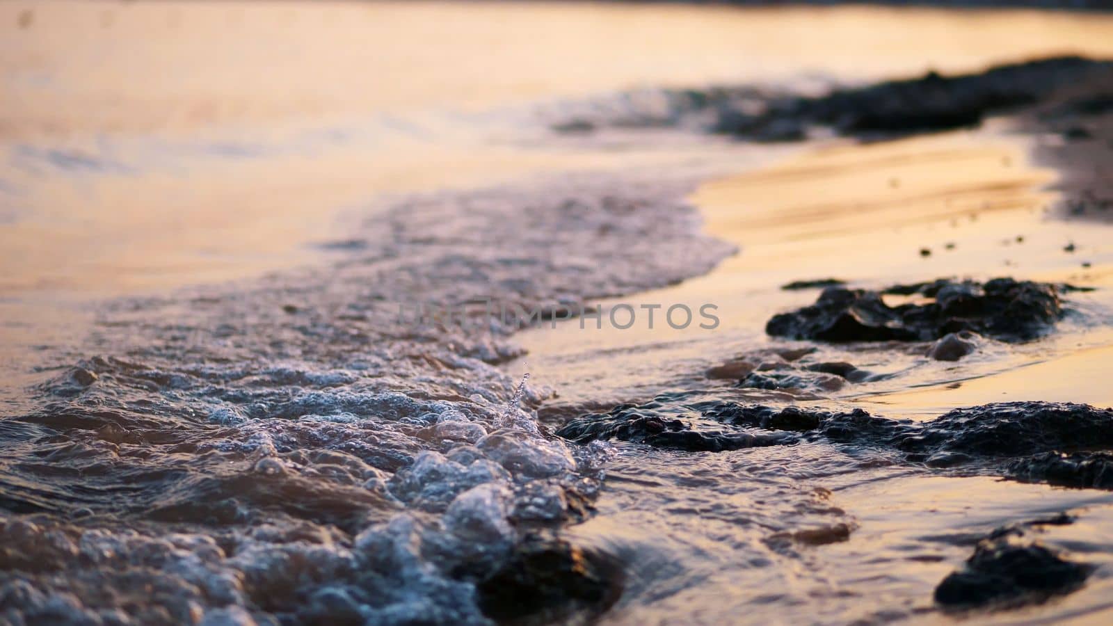 close-up, sea surf, tide, sea waves on the sand beach. in the rays of the sun, warm summer sunset, by djtreneryay