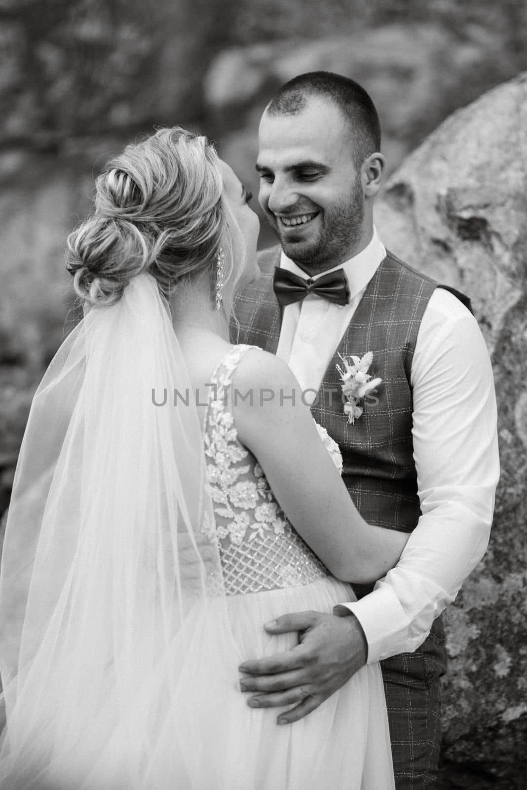 the groom and the bride are walking in the forest on a bright day