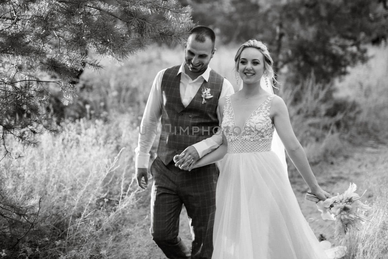 the groom and the bride are walking in the forest on a bright day