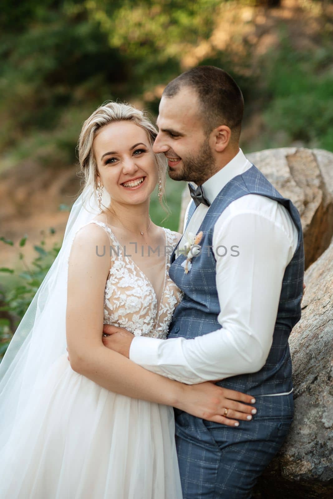 the groom and the bride are walking in the forest on a bright day