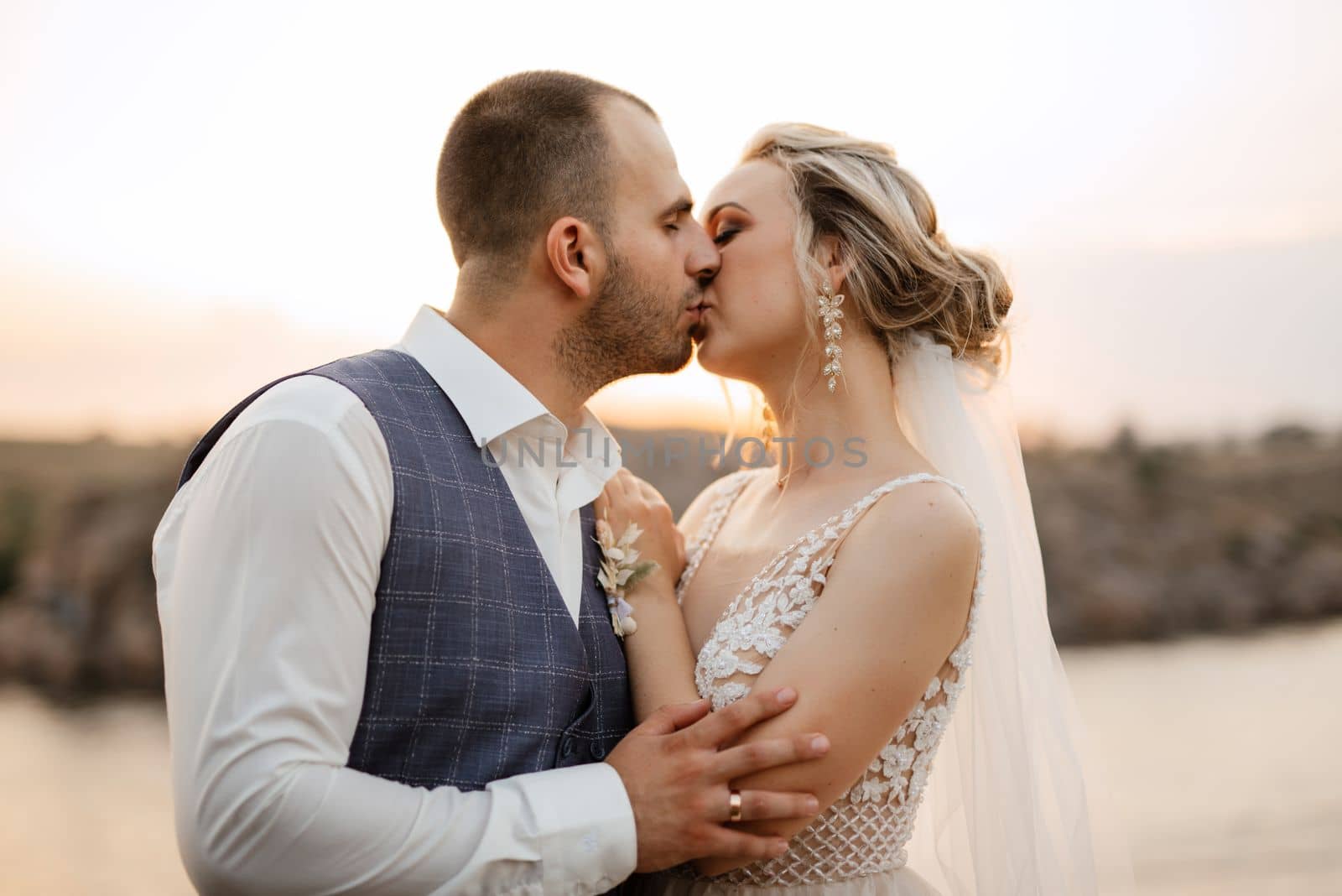 bride blonde girl and groom near the river at sunset light