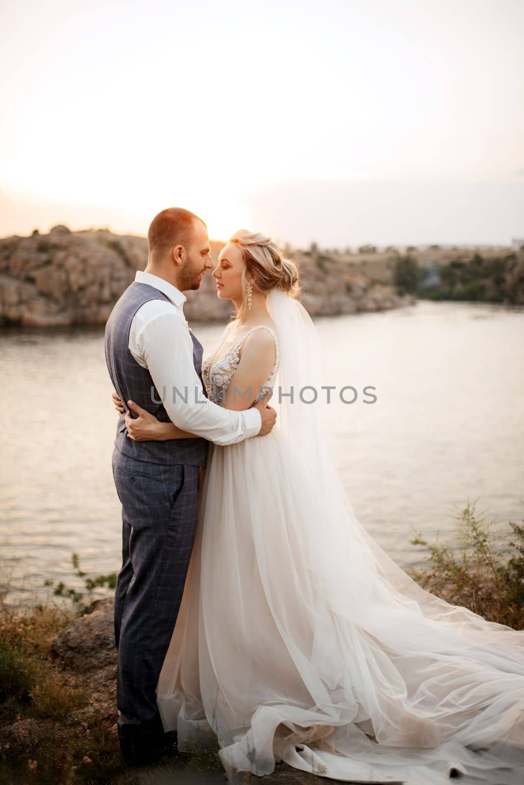 bride blonde girl and groom near the river at sunset light