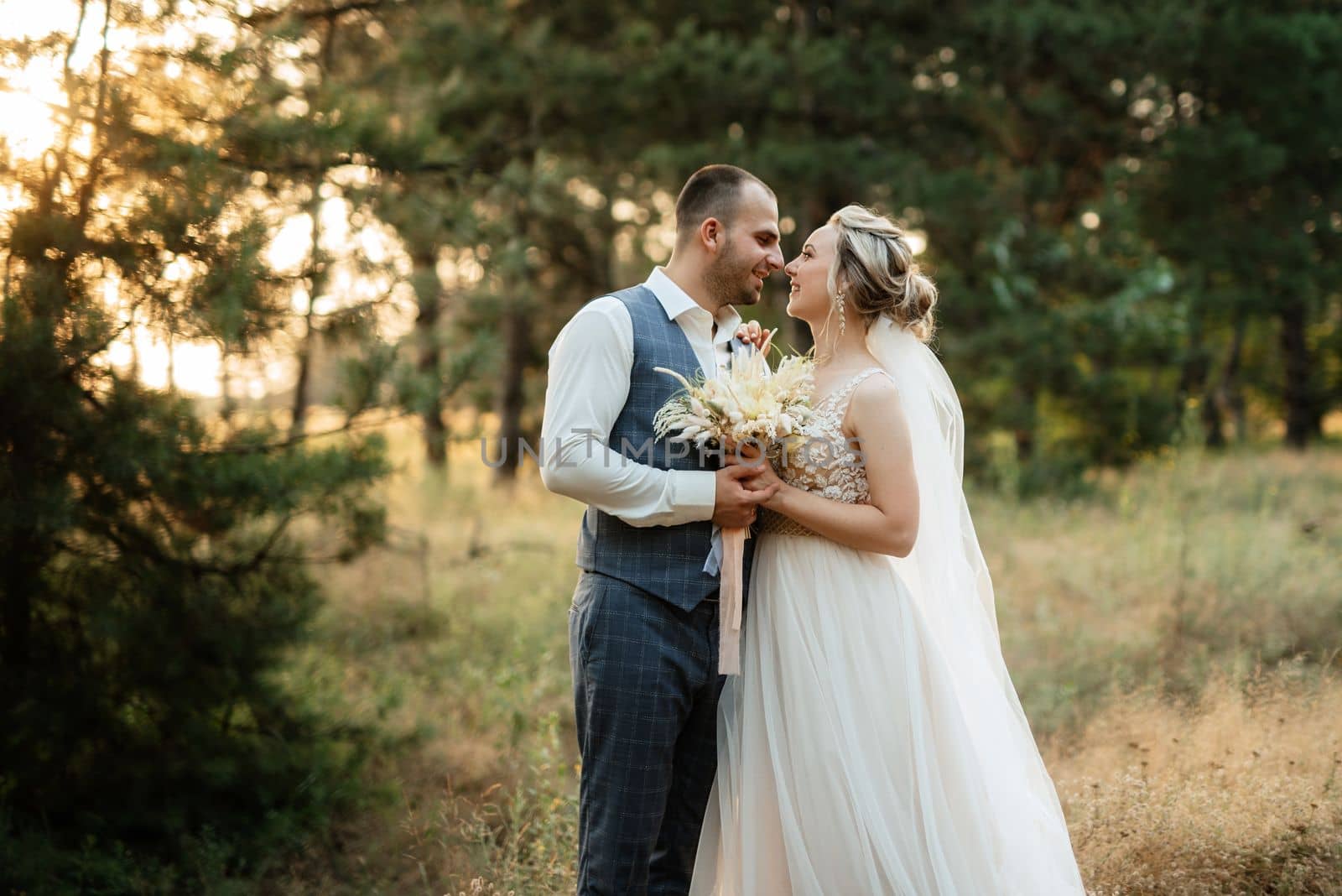 the groom and the bride are walking in the forest on a bright day